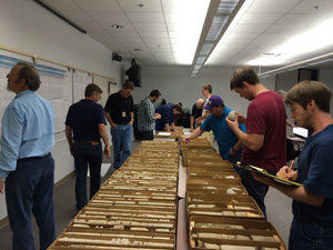 Photo of geologists comparing core to geophysical logs.